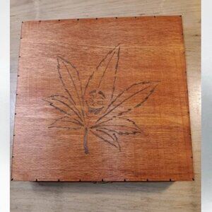 Smiley face pot leaf wood keepsake box with round break.